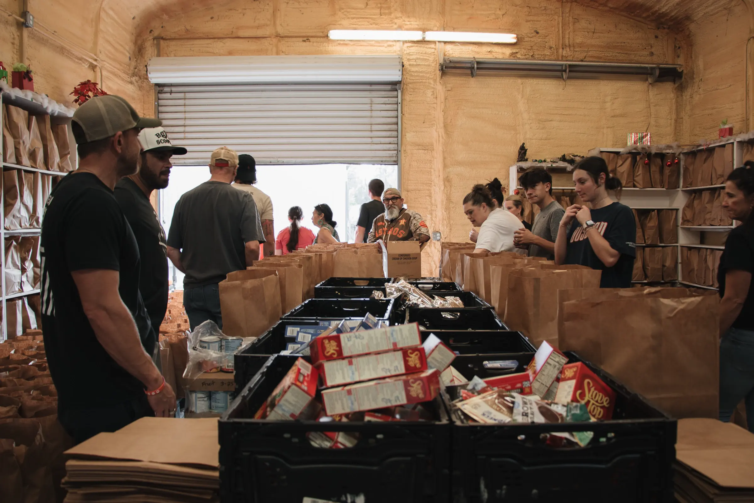 Volunteers pack grocery bags along a table in the pantry.