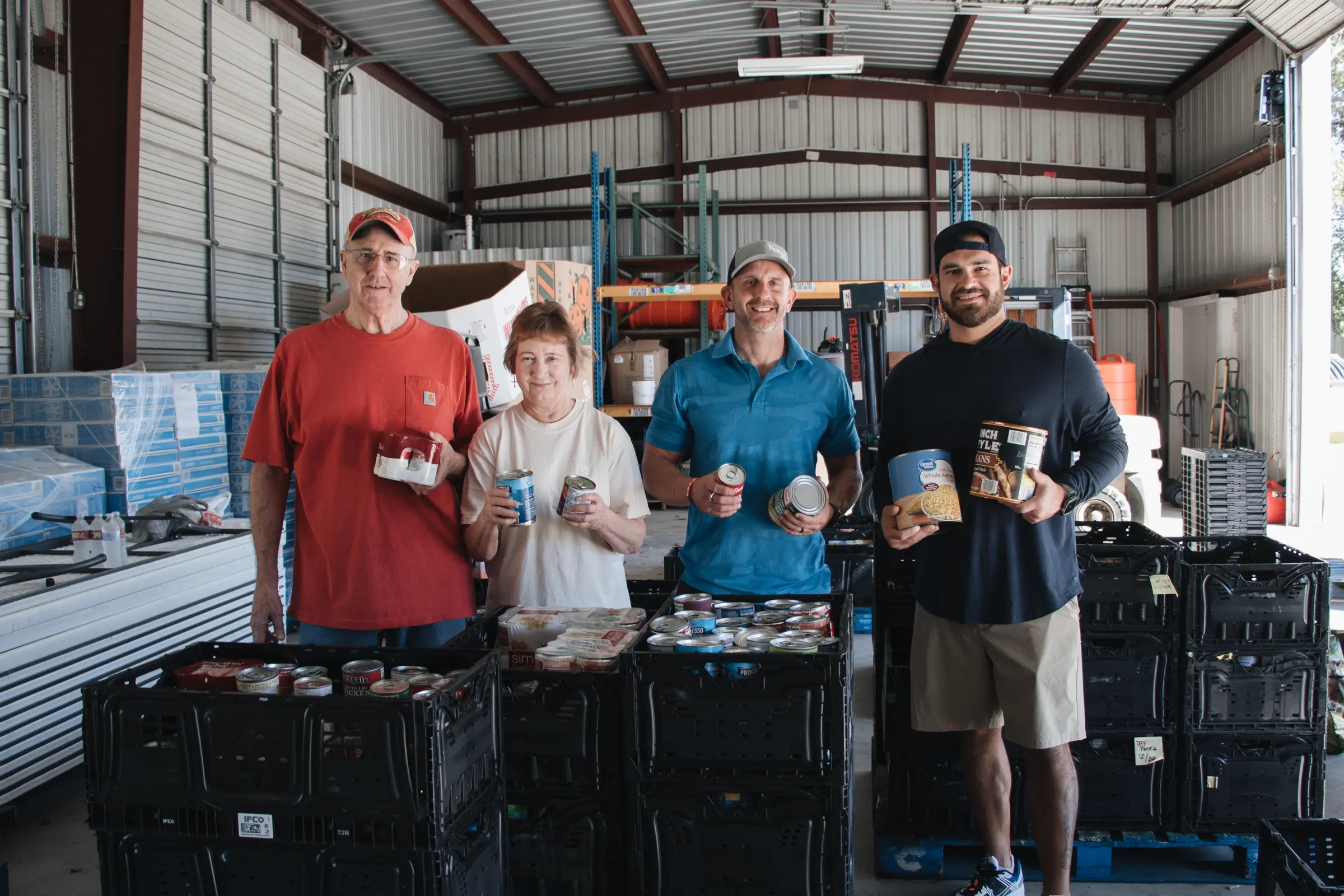 Volunteers hold canned food in the warehouse.